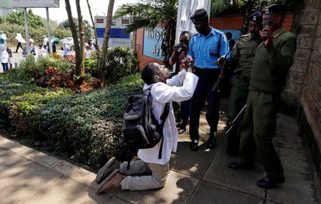 A Kenyan doctor talks to riot policemen as they attempt to disperse striking doctors who demand fulfilment of a 2013 agreement between their union and the government that would raise their pay and improve working conditions outside Ministry of Health headquarters in Nairobi, Kenya December 5, 2016. REUTERS/Thomas Mukoya