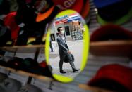 A passerby wearing a protective face mask is reflected in a mirror at a shop as the spread of the coronavirus disease (COVID-19) continues, in Tokyo