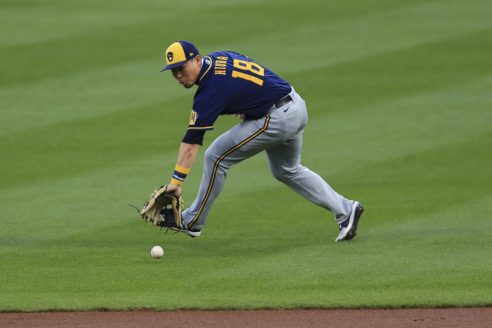 Milwaukee Brewers' Keston Hiura fields the ball and throws out Cincinnati Reds' Joey Votto at first base in the first inning during a baseball game in Cincinnati, Monday, Sept. 21, 2020. (AP Photo/Aaron Doster)