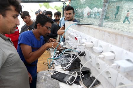 Migrants charge their phones in camp Vucjak in Bihac