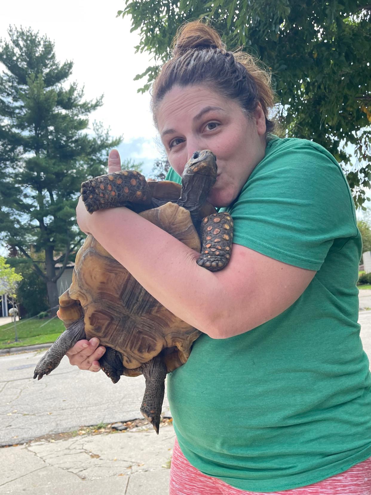 Port Washington resident Brittany Hudson hugs her beloved pet tortoise upon its safe return after it went missing a week ago.