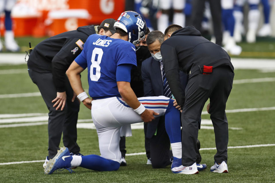 Trainers check New York Giants quarterback Daniel Jones (8) after an injury during the second half of NFL football game against the Cincinnati Bengals, Sunday, Nov. 29, 2020, in Cincinnati. (AP Photo/Aaron Doster)