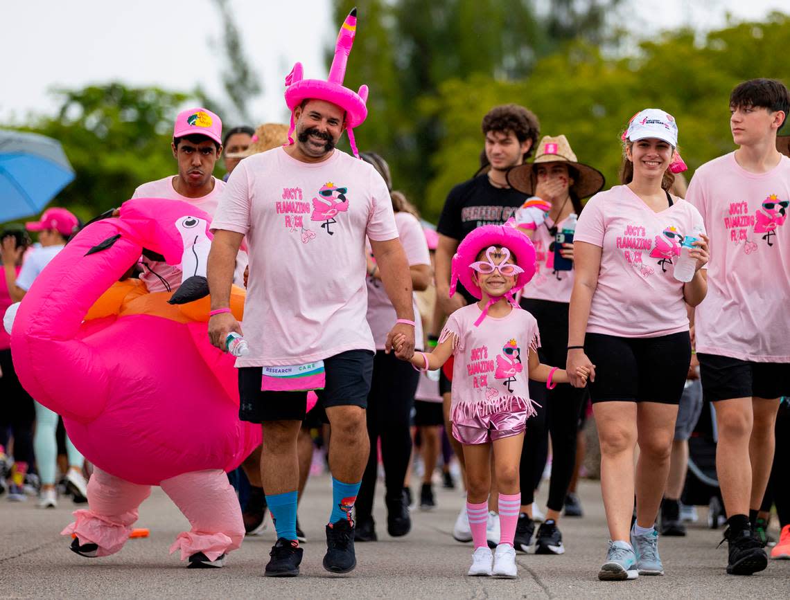 From left to right: Joseph Nerey, Will Fleites, Camila Fleites, 6, and Isabella Fleites, 20, participate in the Susan G. Komen More Than Pink Walk at Amelia Earhart Park on Saturday, Oct. 8, 2022, in Hialeah, Fla. The event aims to raise awareness and money for breast cancer research.