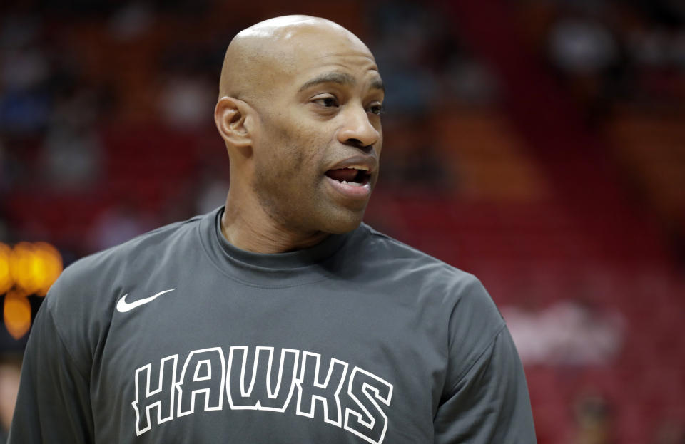 Vince Carter in a gray "HAWKS" warm-up shirt.