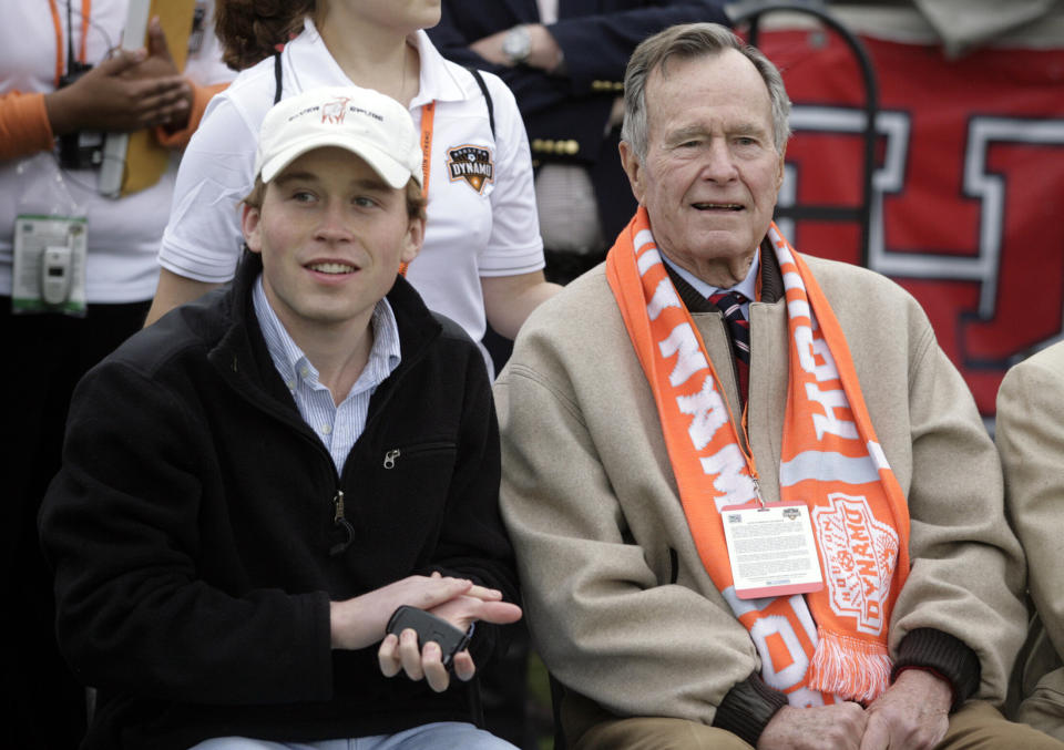 In this file photo, former President George H.W. Bush (right) and grandson Pierce Bush are seen sitting on the sidelines before the Houston Dynamos game against the Los Angeles Galaxy in Houston in April 2007. (Photo: Richard Carson/Reuters)