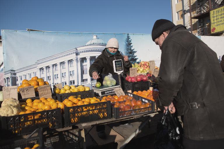 A market vendor sells fruit and vegetables in one of the most shelled places in Donetsk, Ukraine, on November 22, 2014