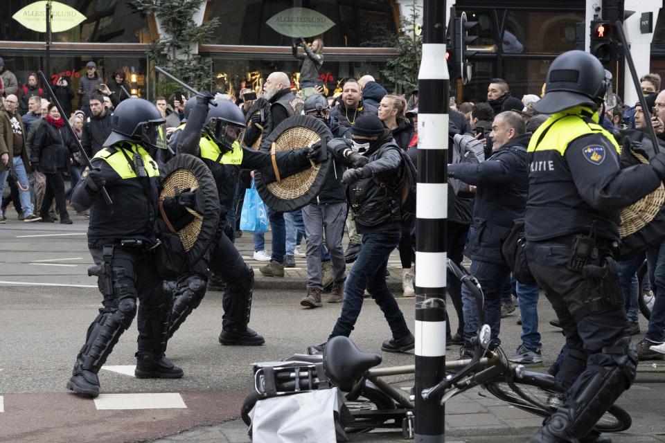 Police clash with demonstrators as thousands of people defied a ban Sunday to gather and protest the Dutch government's coronavirus lockdown measures, in Amsterdam, Netherlands, Sunday, Jan. 2, 2022. The municipality of the Dutch capital banned the protest, saying police had indications some demonstrators could be attending "prepared for violence." (AP Photo/Peter Dejong)