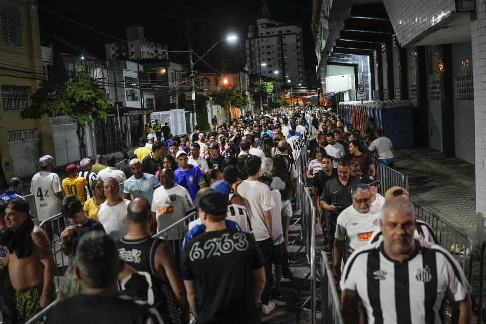 Soccer fans line up to attend the funeral procession of late Brazilian soccer legend Pele at Vila Belmiro stadium where his wake was held in Santos, Brazil, early Tuesday, Jan. 3, 2023. (AP Photo/Matias Delacroix)