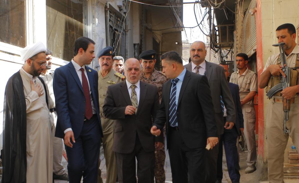 Iraqi Prime Minister Haider al-Abadi (C) walks after a meeting with the top Shiite cleric, Grand Ayatollah Ali al-Sistani, in the Shiite holy city of Najaf, south of Baghdad, October 20, 2014. REUTERS/Alaa Al-Marjani (IRAQ - Tags: POLITICS RELIGION)