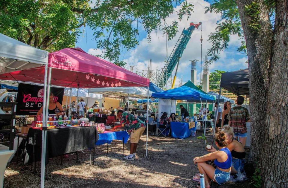 A crane at the Elemi construction site rises above the Coconut Grove Organic Farmers Market on Saturday, August 12, 2023. The Elemi development broke ground on June 7.