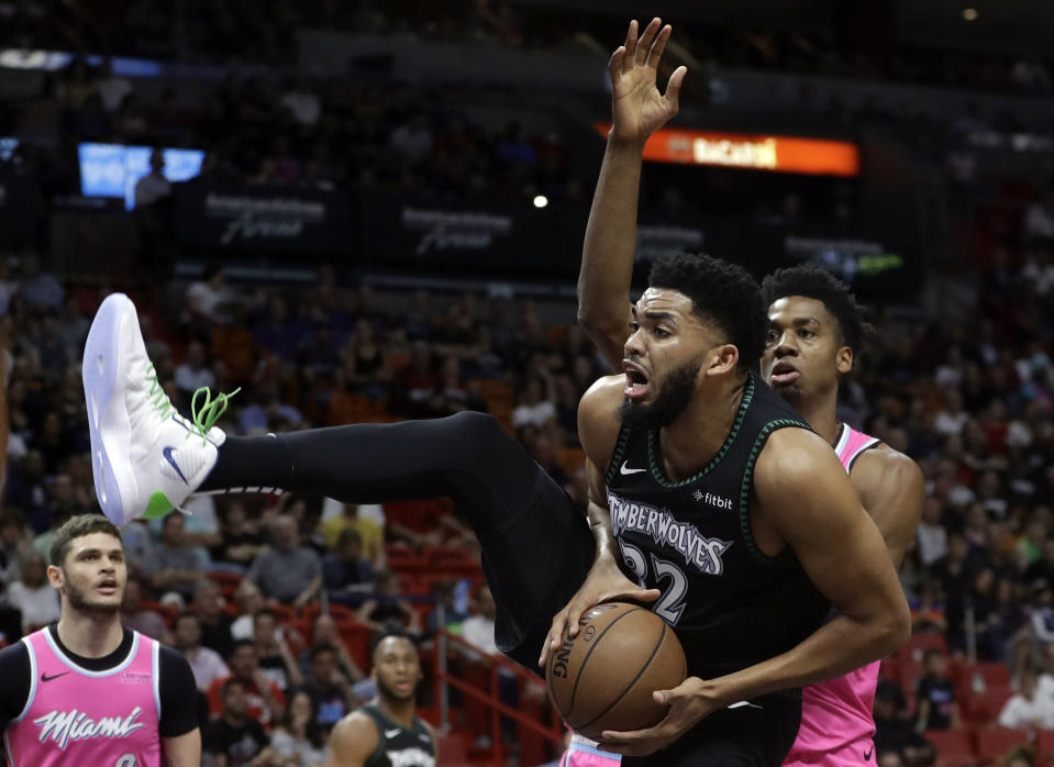 Minnesota Timberwolves center Karl-Anthony Towns (32) goes to the basket as Miami Heat center Hassan Whiteside, right, defends during the first half of an NBA basketball game, Sunday, Dec. 30, 2018, in Miami. (AP Photo/Lynne Sladky)