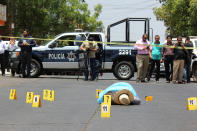 <p>Evidence identifiers are placed next to the body of journalist Javier Valdez at a crime scene in Culiacan, In Sinaloa state, Mexico on May 15, 2017. (Jesus Bustamante/Reuters) </p>