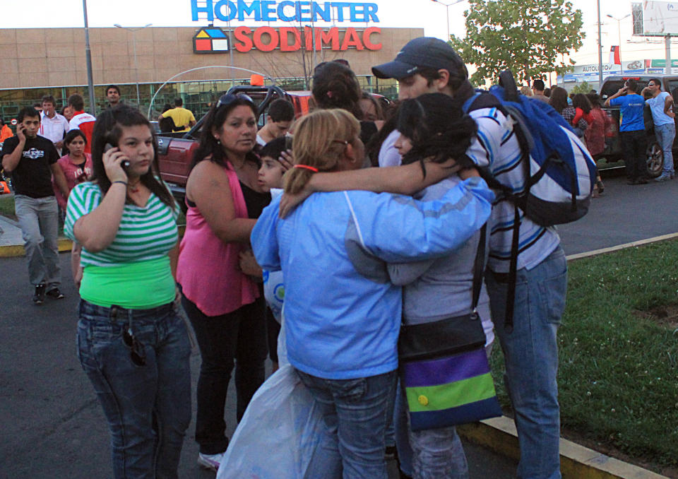 People gather outside a supermarket after an earthquake was felt in Talca, Chile, Sunday, March 25, 2012. A magnitude-7.2 earthquake has struck just off the coast of central Chile, prompting an emergency evacuation order for people living near the ocean in case it spawns a tsunami. (AP Photo/Fabian Suazo)