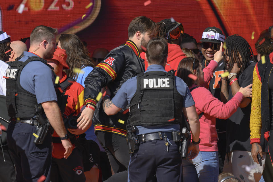 Police clear the Kansas City Chiefs off the stage after a shooting at the end of their Super Bowl victory rally in Kansas City, Mo., Wednesday, Feb. 14, 2024. Authorities in Kansas City are trying to decipher who was behind the mass shooting that unfolded Wednesday.(AP Photo/Reed Hoffmann)