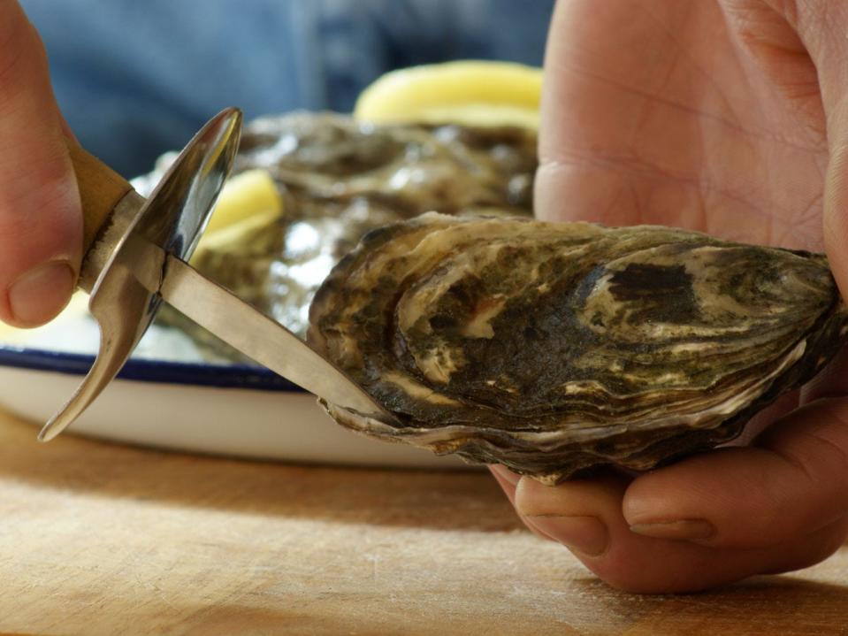 a person shucking an oyster