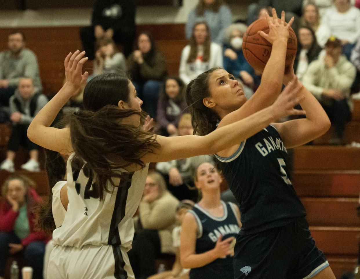 Gananda's Eva Jenny goes for a layup while East Rochester's Gianna Romach defends.