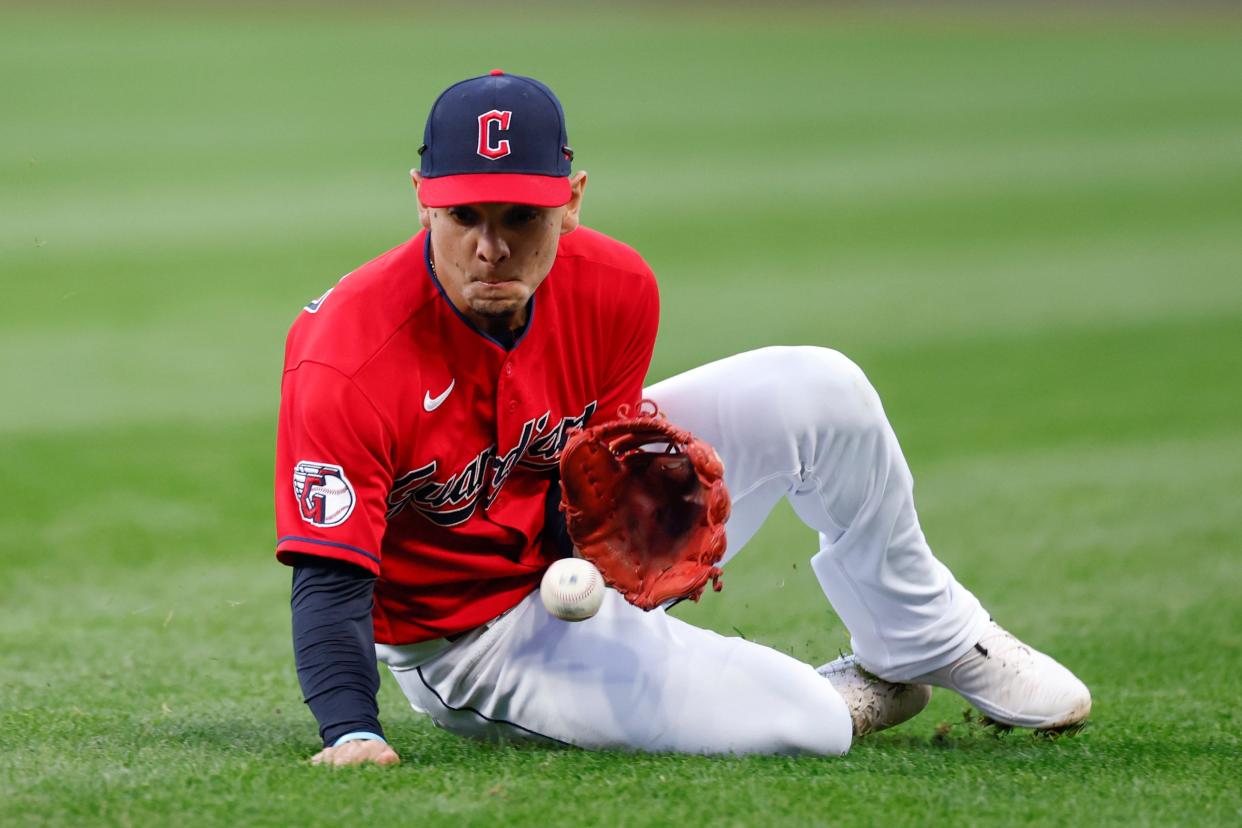 Cleveland Guardians second baseman Andres Gimenez makes a sliding stop, before throwing out Kansas City Royals' Nicky Lopez at first base during the third inning of a baseball game, Tuesday, Oct. 4, 2022, in Cleveland. (AP Photo/Ron Schwane)