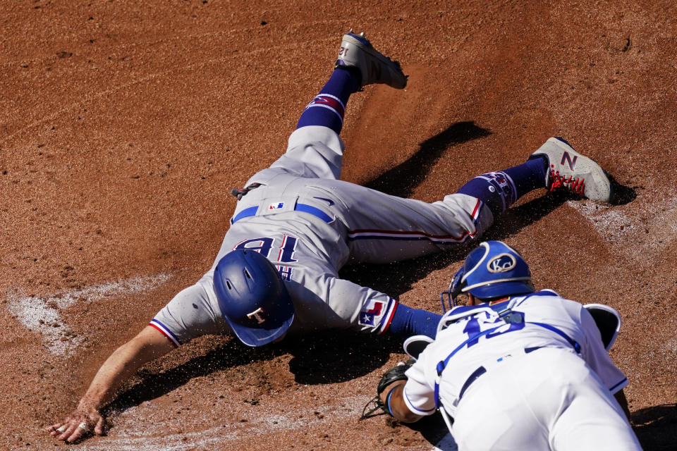 Texas Rangers' Brock Holt (16) is tagged out by Kansas City Royals catcher Salvador Perez trying to score on a single by Jose Trevino during the first inning of a baseball game Thursday, April 1, 2021, in Kansas City, Mo. (AP Photo/Charlie Riedel)