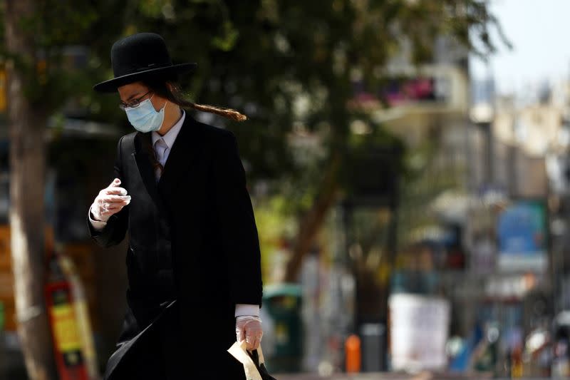 An ultraorthodox Jewish man wears a face mask while walking on a street in Bnei Brak as Israel enforces a lockdown of the ultra-Orthodox Jewish town badly affected by coronavirus disease (COVID-19), Bnei Brak