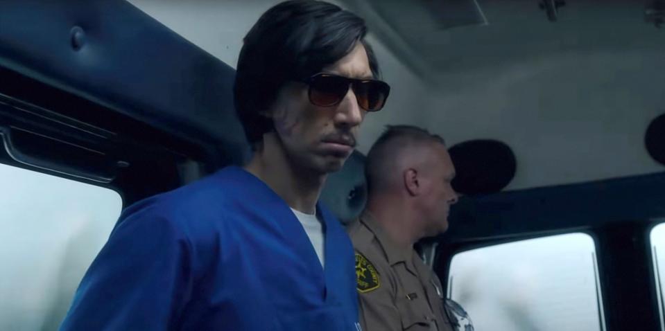 Adam Driver wears sunglasses in the back of a van