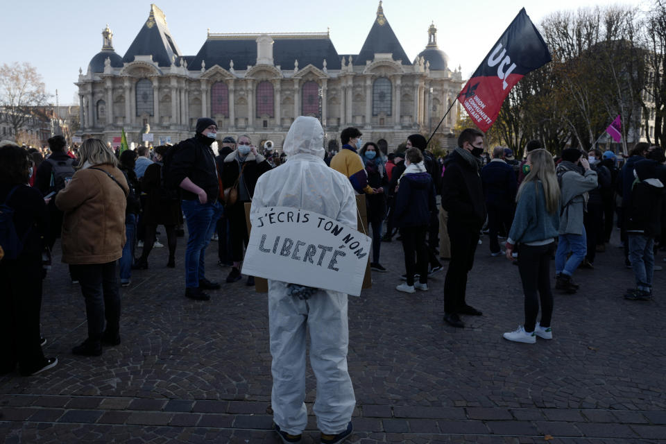 Demonstrator holds a poster reading "I write your name, Freedom", during a demonstration Saturday, Nov. 28, 2020 in Lille, northern France. Critics of a proposed French security law in France that would restrict sharing images of police are gathering across the country in protest. Civil liberties groups and journalists are concerned that the measure will stymie press freedoms and allow police brutality to go undiscovered and unpunished. (AP Photo/Michel Spingler)