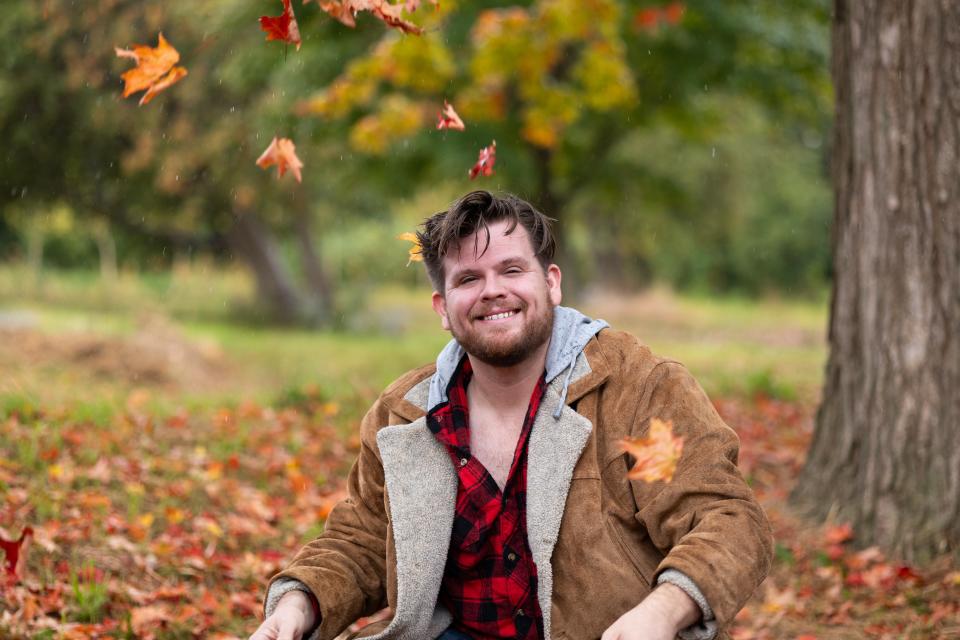 Luke Winkie sits in an autumnal wonderland, as autumn leaves fall in the foreground.