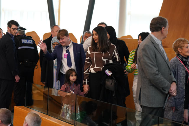 Members of the public, including Mr Yousaf’s wife and child, leaving the public gallery at Holyrood (Andrew Milligan/PA)