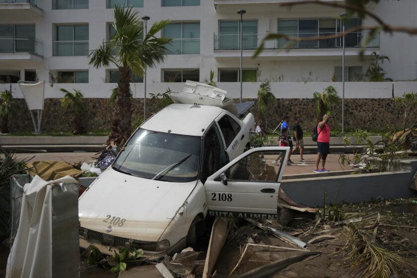 A damaged car lays on a street divider after Hurricane Otis ripped through Acapulco, Mexico, Thursday, Oct. 26, 2023. The hurricane that strengthened swiftly before slamming into the coast early Wednesday as a Category 5 storm has killed at least 27 people as it devastated Mexico's resort city of Acapulco. (AP Photo/Felix Marquez)