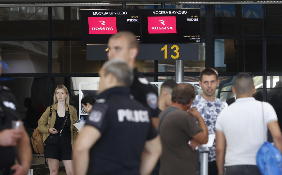 Russian diplomatic staff wait at a check-in counter at Sofia's Airport, Bulgaria, Sunday, July 3 2022. Two Russian airplanes were set to depart Bulgaria on Sunday with scores of Russian diplomatic staff and their families amid a mass expulsion that has sent tensions soaring between the historically close nations, a Russian diplomat said. (AP Photo/Valentina Petrova)