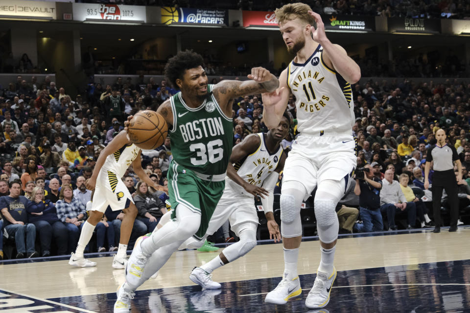 Marcus Smart, base de los Celtics de Boston, dribla a Domantas Sabonis, de los Pacers de Indiana, en el encuentro del martes 10 de marzo de 2020 (AP Foto/AJ Mast)