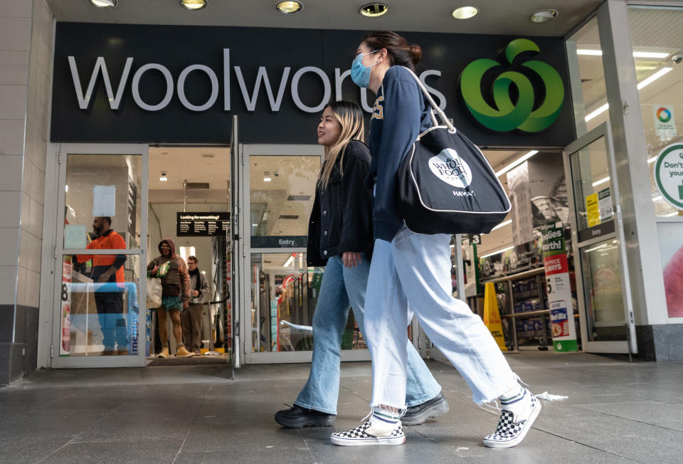 A person wearing a face mask in front of a Woolworths shop. Source: AAP