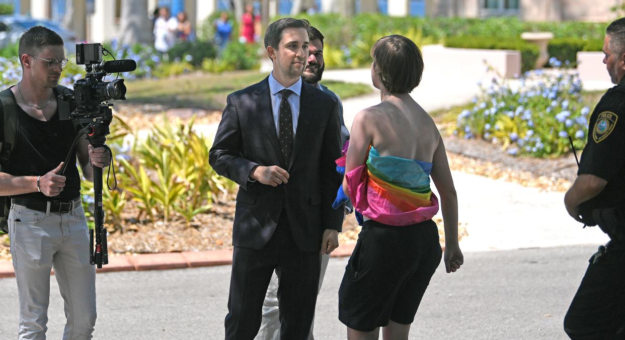 As New College trustee Christopher Rufo approaches the protesters following DeSantis' signing of several higher education bills, Catherine "Libby" Harrity moves toward him.