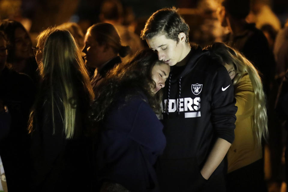 Hannah Schooping-Gutierrez, center, a student at Saugus High School, is comforted by her boyfriend Declan Sheridan, at right, a student at nearby Valencia High School during a vigil at Central Park in the aftermath of a shooting at Saugus Thursday, Nov. 14, 2019, in Santa Clarita, Calif. (AP Photo/Marcio Jose Sanchez)