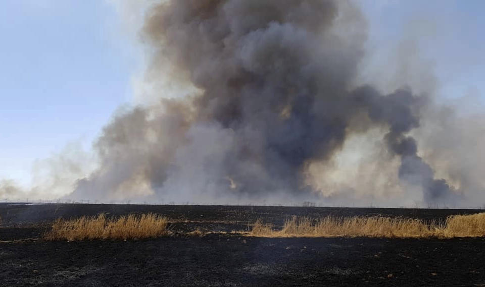 This Tuesday, May 28, 2019 photo, provided by the community service group, Together for Jarniyah, which has been authenticated based on its contents and other AP reporting, shows Syrians working to extinguish a fire in a field of crops, in Jaabar, Raqqa province, Syria. Crop fires in parts of Syria and Iraq have been blamed on defeated Islamic State group militants in the east seeking to avenge the group’s losses, and on Syrian government forces in the west battling to rout other armed groups there. (Together for Jarniyah via AP)