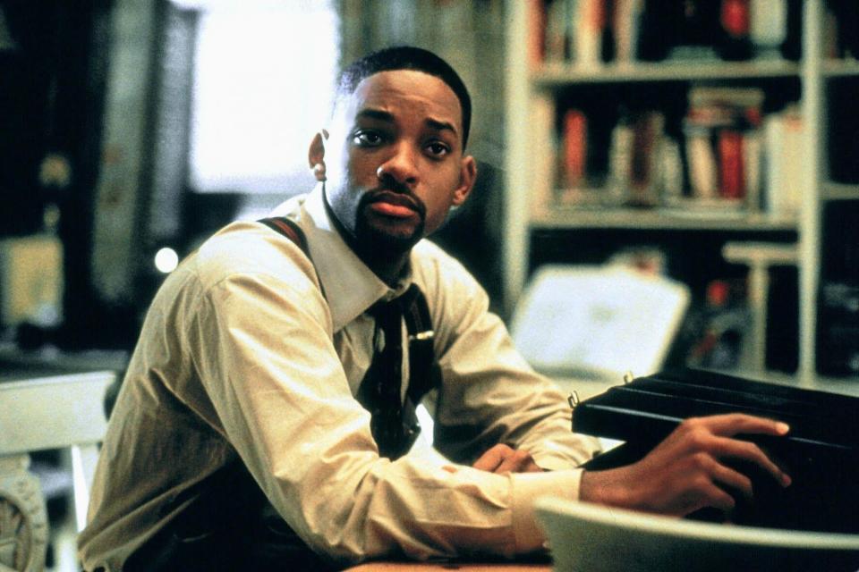 Will Smith looks concerningly while sitting near a briefcase