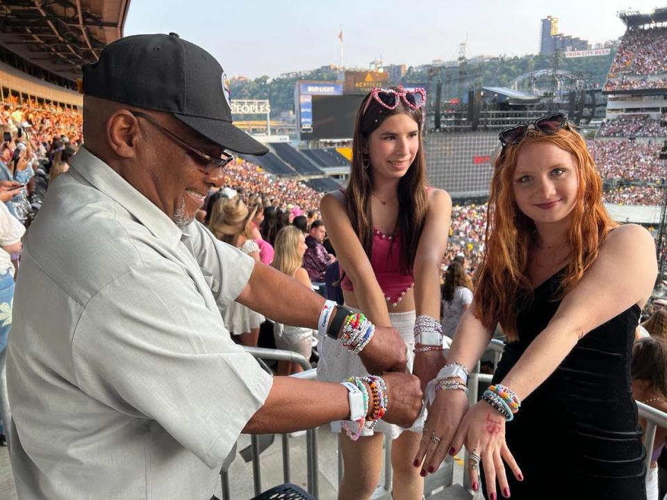 A stadium employee displays his friendship bracelets with Skylie Mazey, right, and Paige Balint at Acrisure Stadium in downtown Pittsburgh during the June 17 Taylor Swift concert.