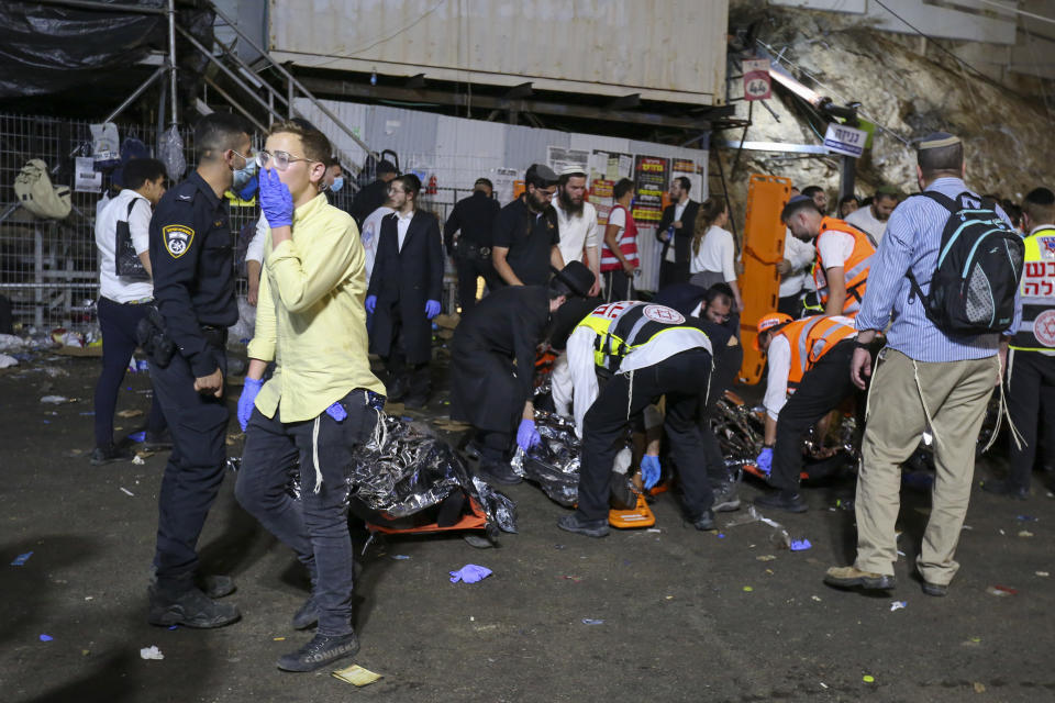 Israeli security officials and rescuers carry bodies of victims who died during a Lag Ba'Omer celebrations at Mt. Meron in northern Israel, Friday, April 30, 2021. Israel's national rescue service has officially confirmed some deaths at a stampede during a religious festival in northern Israel. (David Cohen/JINIPIX via AP)