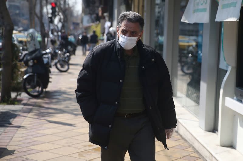 An Iranian man wears a protective face mask, following the coronavirus outbreak, as he walks in Tehran
