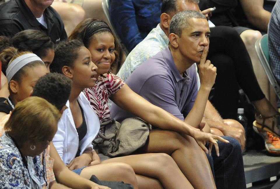 President Barack Obama, first lady Michelle Obama, their daughters Sasha and Malia and other family members watched the Oregon State University vs. University of Akron college basketball game at the Diamond Head Classic at the Stan Sheriff Center in Honolulu, on December 22, 2013.