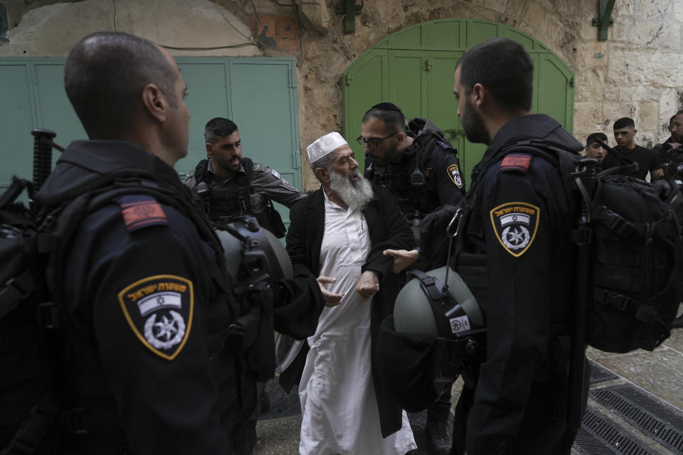 Israel police argues with a Palestinian worshipers the Old City of Jerusalem, Sunday, April 17, 2022. Israeli police clashed with Palestinians outside Al-Aqsa Mosque after police cleared Palestinians from the sprawling compound to facilitate the routine visit of Jews to the holy site and accused Palestinians of stockpiling stones in anticipation of violence. (AP Photo/Mahmoud Illean)