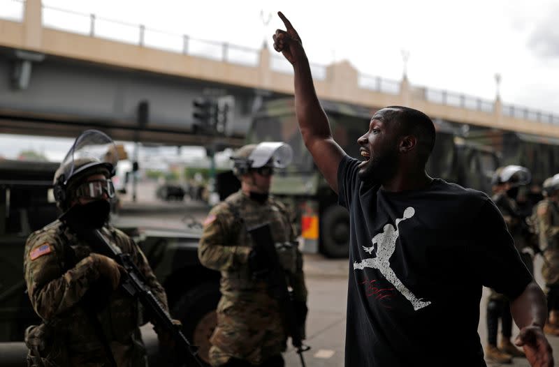 A man gestures as he confronts National Guard members guarding the area in the aftermath of a protest in Minneapolis