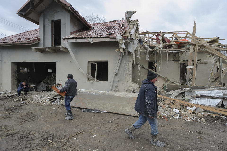 Villagers clear the rubble after Russia's night rocket attack ruined private houses in a village in Zolochevsky district in the Lviv region, Ukraine, Thursday, March 9, 2023. (AP Photo/Mykola Tys)