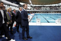 French President Emmanuel Macron, surrounded by Tony Estanguet, president of the Paris 2024 Olympics Organising Committee, left, Ile-de-France's Regional Council President Valerie Pecresse, third left, and Grand Paris' Metropole President Patrick Ollier visit the Olympic Aquatics Center (CAO), a multifunctional venue for the 2024 Paris Olympic in Saint-Denis, near Paris, Thursday, April 4, 2024. The aquatic center will host the artistic swimming, water polo and diving events during the Paris 2024 Olympic Games. (Gonzalo Fuentes/Pool via AP)