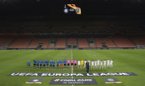 Inter Milan, left, and Ludogorets line-up inside the empty San Siro stadium in Milan, Italy ahead of their Europa League round of 32 second leg soccer match Thursday Feb. 27, 2020. Inter beat Ludogorets 2-1 in an empty stadium as a precaution because of the virus outbreak in Italy. (Emilio Andreoli, UEFA via AP )