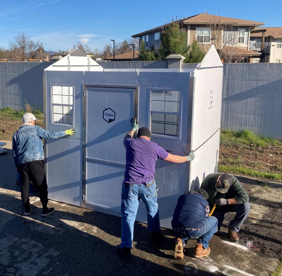 Volunteers put up the first of eight micro-shelters on Mark Street behind the Redding Area Bus Authority headquarters on Monday, Feb. 6, 2023.