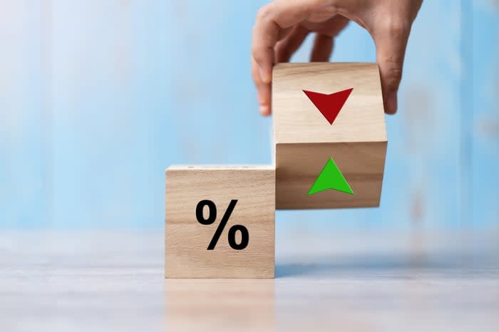 Cube blocks with a percentage sign and a hand holding a block with a red up and green down symbol.