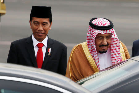 Saudi Arabia's King Salman (R) walks with Indonesia President Joko Widodo as he arrives at Halim Perdanakusuma airport in Jakarta, Indonesia March 1, 2017. REUTERS/Beawiharta