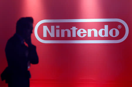 FILE PHOTO: A man stands in front of Nintendo's logo at the presentation ceremony of its new game console Switch in Tokyo, Japan January 13, 2017. Picture taken January 13, 2017. REUTERS/Kim Kyung-Hoon