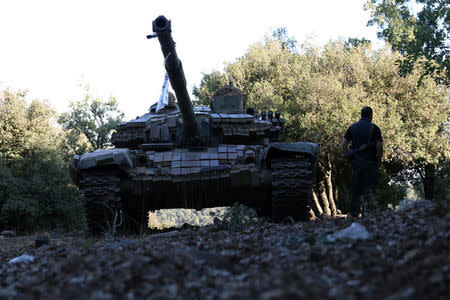 A rebel fighter walks next to a tank in Jubata al-Khashab, in Quneitra countryside, Syria September 11, 2016. REUTERS/Alaa Al-Faqir