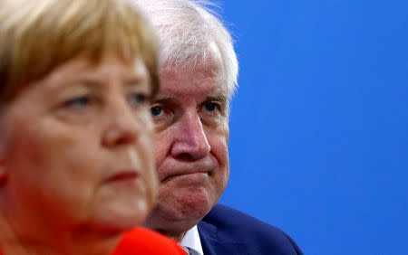 FILE PHOTO: German Chancellor Angela Merkel and Interior Minister Horst Seehofer address a news conference following the so called a housing summit on rising rents in many German cities and a general shortage of affordable housing in Berlin, Germany September 21, 2018. REUTERS/Fabrizio Bensch/File Photo